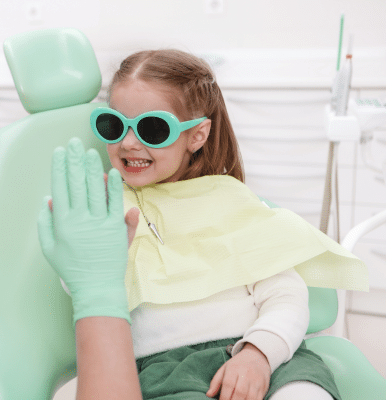 Little girl wearing sunglasses at the dentist office, representing Central Park Pediatric Dentistry